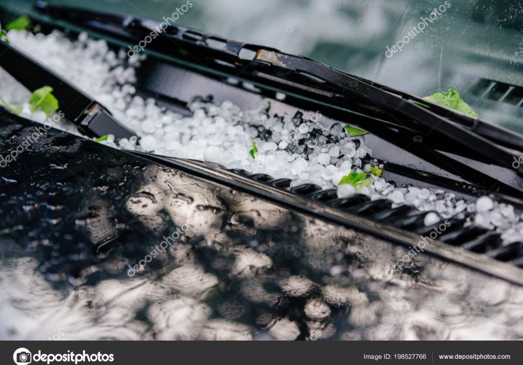 Large hail ice balls on car hood after heavy summer storm